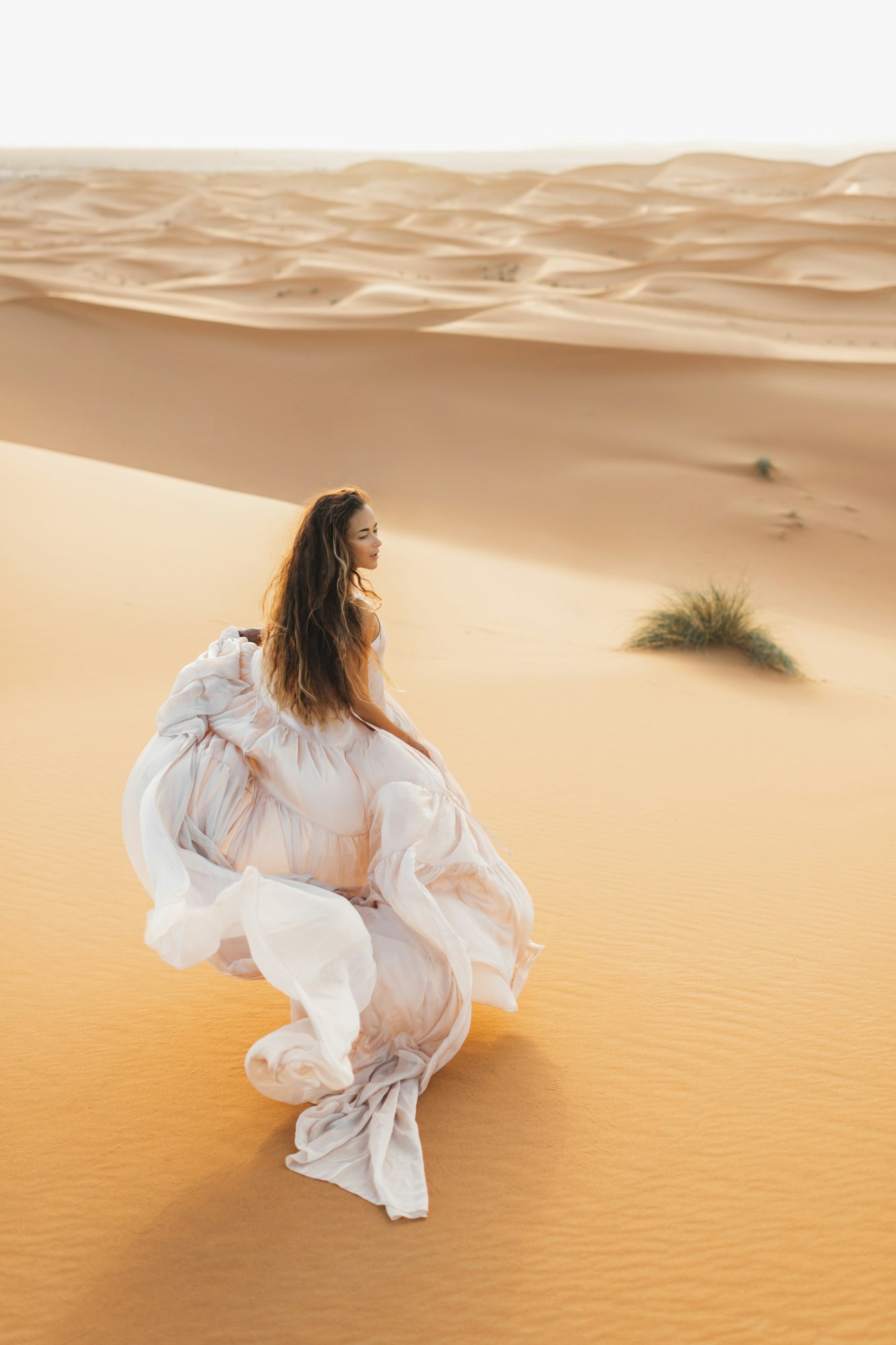 Portrait of bride woman in amazing wedding dress in Sahara desert, Algeria . Warm evening light